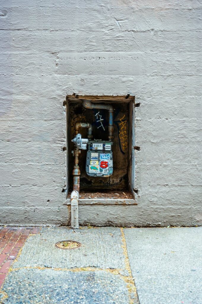 A utility meter box embedded in a wall on a Seattle sidewalk, displaying urban graffiti.