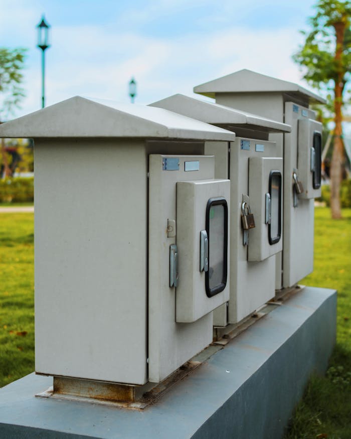 Close-up of locked electric boxes outdoors, featuring metal cabinets on a platform.